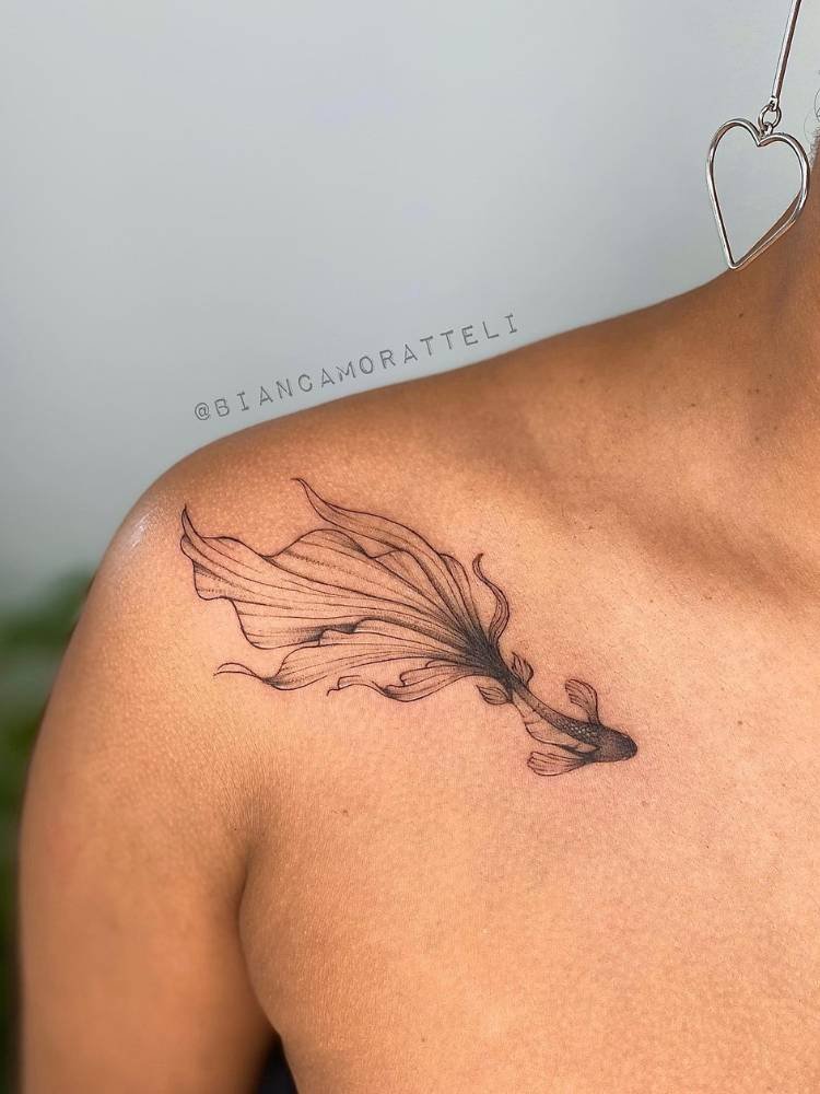 tatuagem-feminina-ombro-peixe Mulher de pele morena com peixe fine line sombreado tatuado no ombro