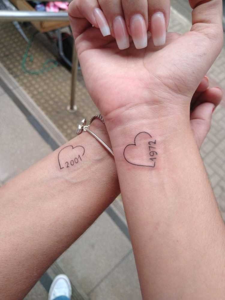 tatuagem-mae-e-filha-coracao dois braços com tatuagem de coração, ano na borda