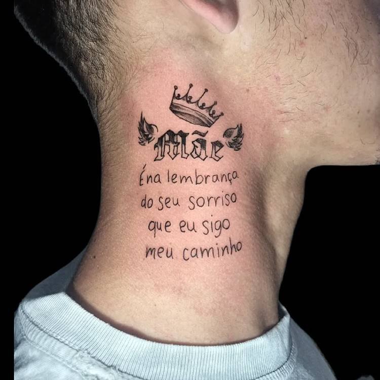 tatuagem-mae-pai-10 A imagem exibe uma tatuagem no pescoço de uma pessoa, apresentando a palavra "Mãe" com asas e uma coroa acima. Abaixo, a frase "É na lembrança do seu sorriso que eu sigo meu caminho" é escrita em outra fonte. A tatuagem é em preto e o fundo escuro realça a pele.