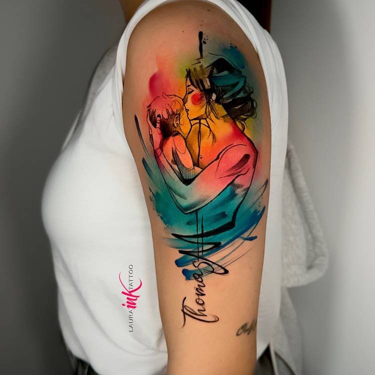 tatuagem-mae-para-filho-1 Tatuagem colorida de mãe beijando o filho, estilo aquarela, no braço