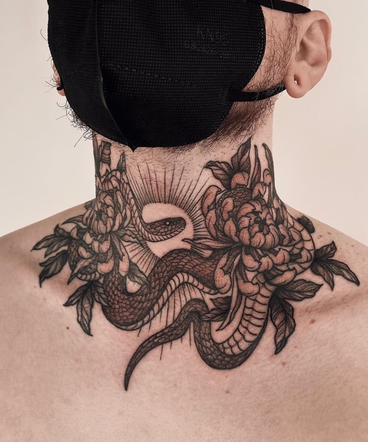 tatuagem-masculina-no-pescoco-11 A imagem mostra uma pessoa usando uma máscara preta. Ela tem uma tatuagem no pescoço de uma cobra entre flores, com detalhes finos em preto. A tatuagem cobre a parte da frente do pescoço e se estende até a parte superior das costas.