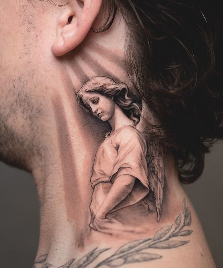 tatuagem-masculina-no-pescoco-22 A imagem mostra uma pessoa de perfil com cabelo escuro e ondulado. Ela tem uma tatuagem no pescoço de um anjo em tons de cinza, com asas detalhadas e expressão serena. A tatuagem cobre a lateral do pescoço, desde a orelha até a clavícula, com grande realismo.