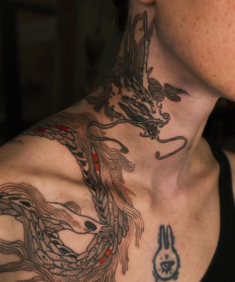 tatuagem-masculina-no-pescoco-5 A imagem mostra uma pessoa com barba e cabelo curto. Ela tem uma tatuagem no pescoço de um dragão em preto e vermelho. A tatuagem cobre a lateral do pescoço, com detalhes intricados e sombreados, criando um efeito dramático e impressionante.
