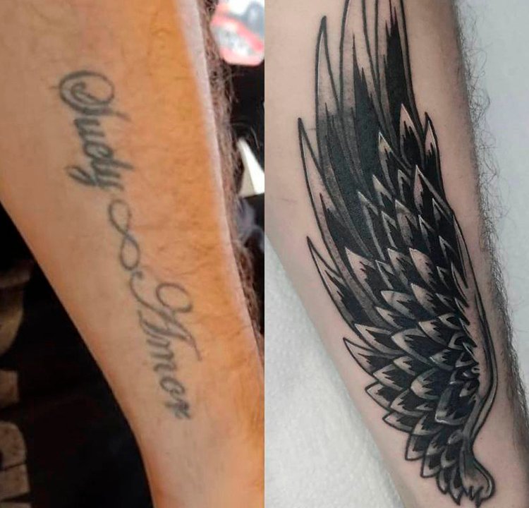 Cobertura de tatuagem no braço Uma tatuagem de asas cobre uma antiga escrita.