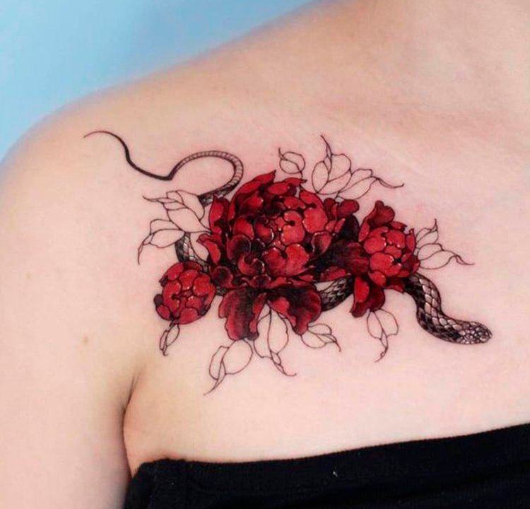 Tatuagem colorida na clavícula A foto de uma tatuagem de uma cobra cercada de flores vermelhas.