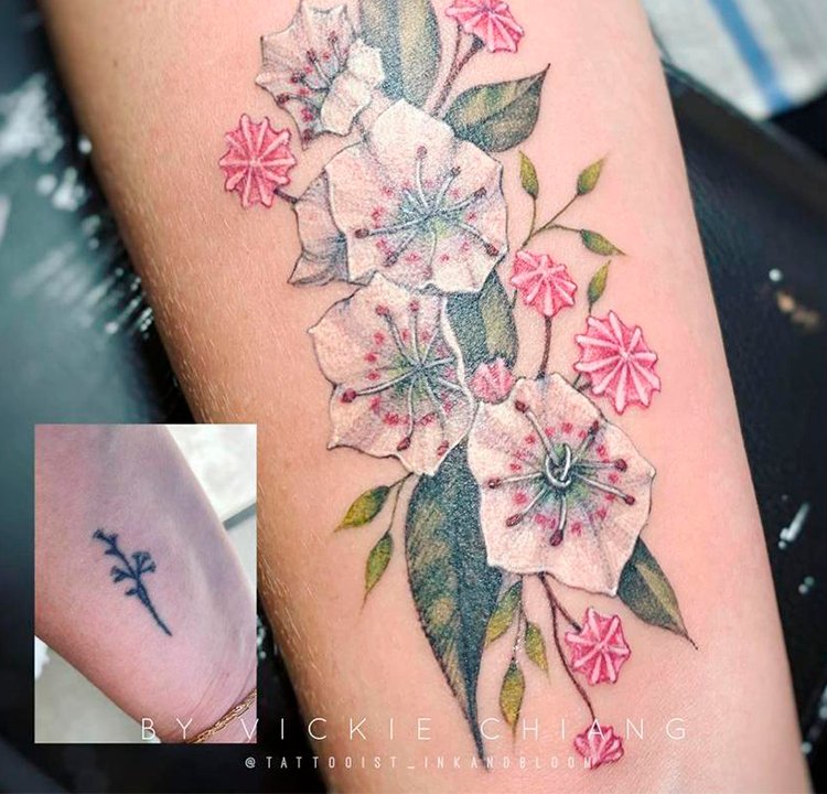 Cobertura de tatuagem Tatuagem de flores coloridas cobre uma antiga e menor de flores pretas.