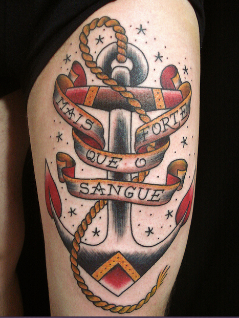 Tatuagem Old School de âncora preta e vermelha com frase "mais forte que o sangue" em flâmula